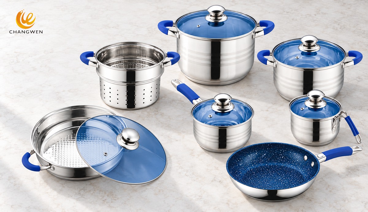 Batería de cocina de acero pulido con asas azules, tapas azules, vaporera y sartén azul dispuestas para distinguir componentes